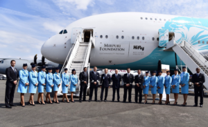 giovani professionisti felici davanti a aereo neos