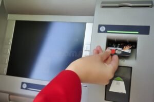sportello atm con mano che inserisce carta